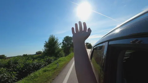 Feeling the wind while driving through countryside, man reaching out hand fro Video stock 136598738