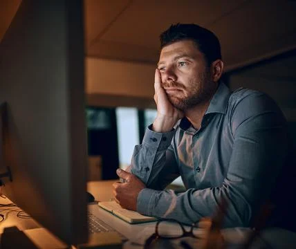Feeling zero inspiration right now. a young businessman looking bored while Stock Photos