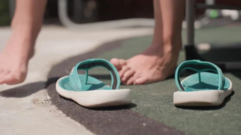 Feet and Turquoise Flip Flops Transition from Ground to Worn in Outdoor Setting Stock Footage 345970440
