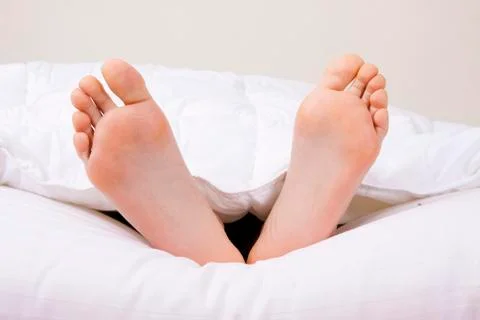 Feet in bed Stock Photos