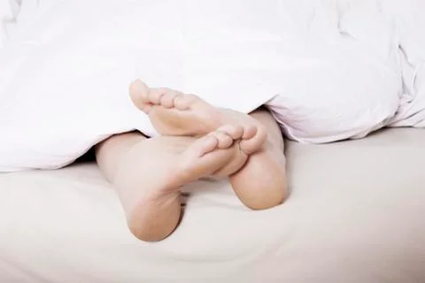 Feet in bed Stock Photos