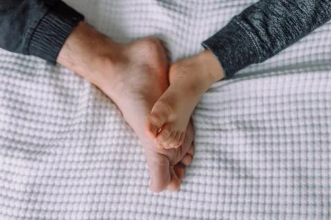 Feet of big daddy and tiny son Stock Photos