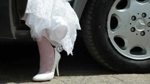 Feet of  bride in  wedding dress leaving of  car Stock Footage