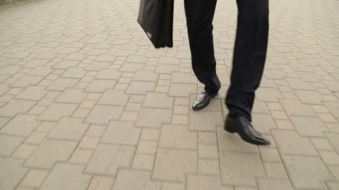 Feet of the businessman dancing on street. Steadicam shot, slow motion Stock Footage