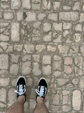 Feet on the cobblestone path Stock Photos