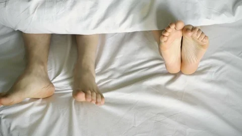Feet dancing under a white blanket, on a white bed, top view.4k Vídeo Stock 106539528