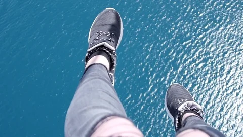 Feet Dangle Over Ocean While Parasailing Stock Footage