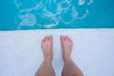 Feet at the edge of the pool Stock Photos