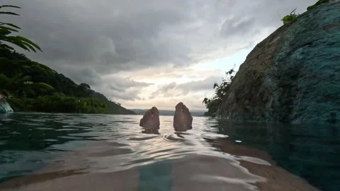 Feet floating in infinity pool Stock Footage 257657039