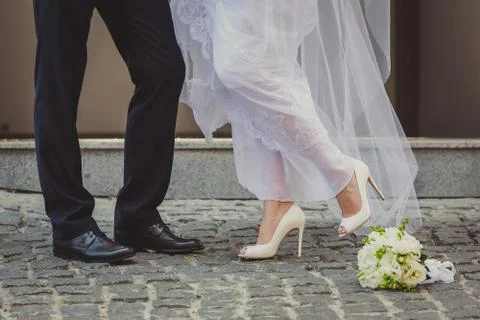 Feet in footwear of the groom and the bride Stock Photos