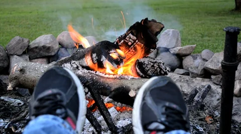 Feet up in front of campfire Stock Footage 37013889