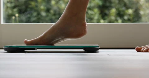Feet going on a bathroom scale Stock Footage 166716135