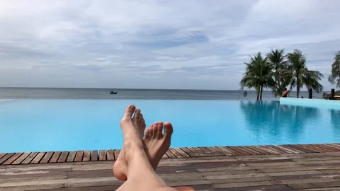 Feet at infinity pool by the ocean in Vietnam Stock Footage 107572980