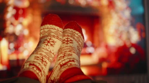 Feet in Knitted Red and White Socks Resting by Fireplace with Blurred Background Stock Footage 340264480