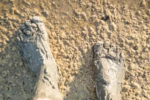 Feet in the mud on a beautiful background. Bare feet in clay Stock Photos