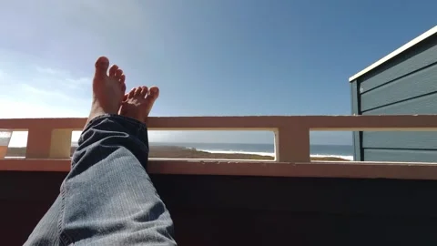 Feet on patio in front on ocean Stock Footage 285354767