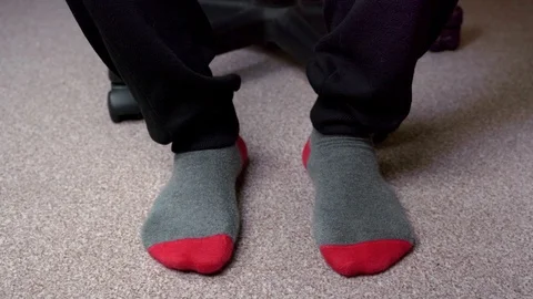 Feet in red-grey socks on a light brown carpet Stock-Footage 124550328