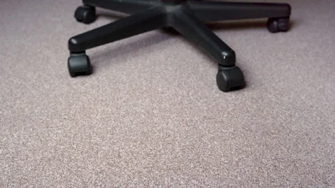 Feet in red-grey socks on a light brown carpet spin on a chair Stock-Footage 124575467