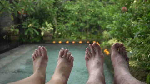 Feet of a resting couple on the background of the pool in the rain. Stock Footage 104494417