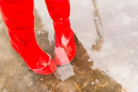 Feet in rubber boots in the spring pool Stock Photos