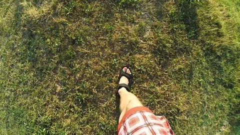Feet in sandals walking on earth and green grass Stock Footage 87966853