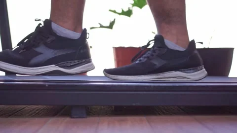 Feet in sneakers walking on treadmill machine, close up view, home gym workout, Stock Footage 344431767
