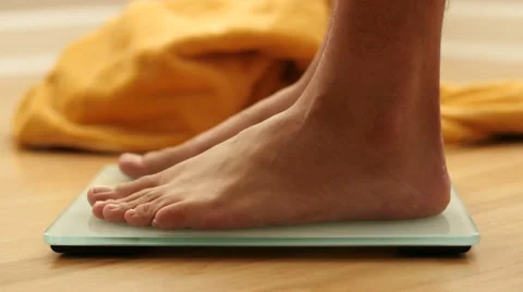 Feet stepping onto a scale, close up shot 動画素材 47853679
