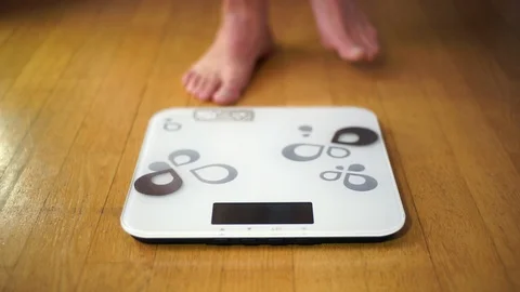 Feet stepping onto a scale Stock Footage 89961606