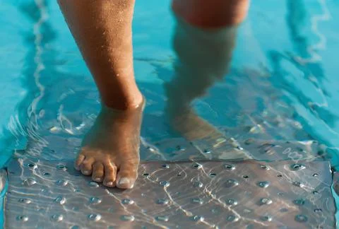 Feet on the steps of the pool Stock Photos