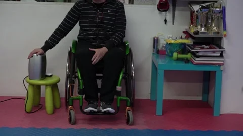 Feet of tae kwon do teacher in wheelchair while athletes run to warm up in f Video stock 142119853