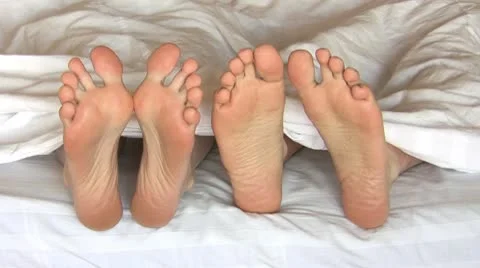 Feet under blanket Stock Footage 10576618