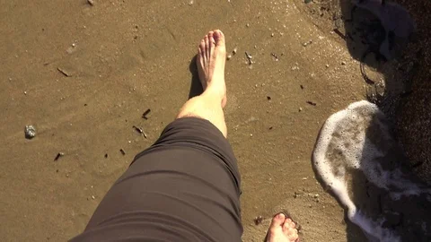 Feet view of a man walking on the sand of a beach Stock Footage 120729896