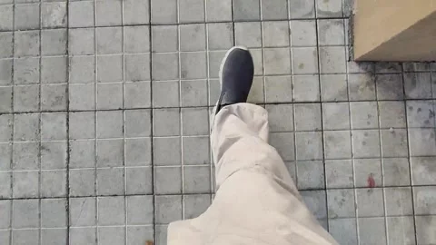 Feet walking on a square tile floor in a day time, Stock Footage 306450919