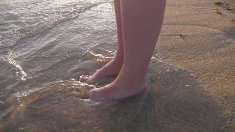 Feet in Water Waves on Sandy Beach with Sea Foam on Coast. Young Woman Stood Stock Footage 94492663