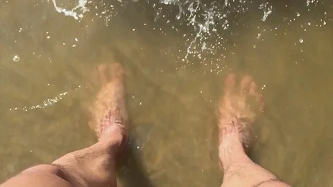 Feet waves man of sea slow motion video. male tourist is standing with his feet Stock Footage