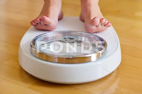 Feet of a woman on bathroom scale Stock Photos