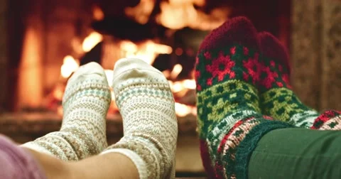 Feet in woolen socks warming by cozy fire. Mother and child near the fireplace. Stock Footage 54684666