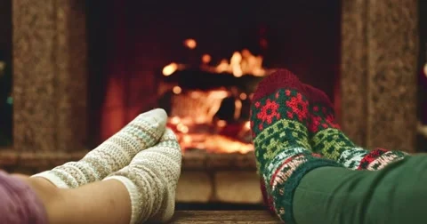 Feet in woolen socks warming by cozy fire. Mother and child near the fireplace. Vídeos de archivo 54684973