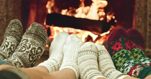 Feet in woolen socks warming by cozy fire. Family with two kids near fireplace. Stock Footage 54685530