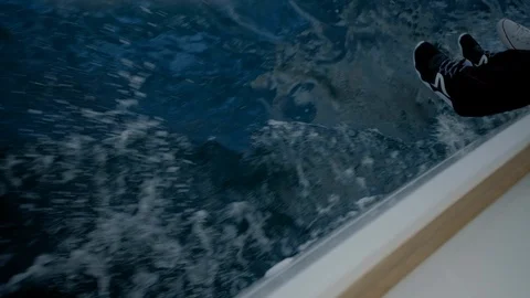 Feets  hanging over the boat sailing on the sea. Lifestyle relaxing legs Video stock 109420180