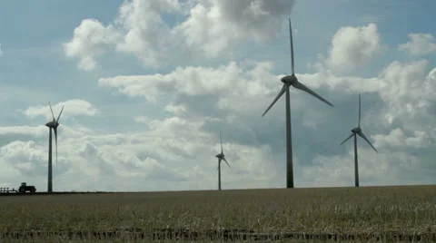 Fehmarn, A tractor moves on the field with wind turbines Stock Footage 41592384