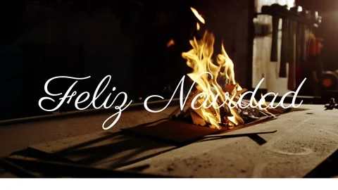 Feliz Navidad text over burning papers in dimly lit room Stock Footage 330474505