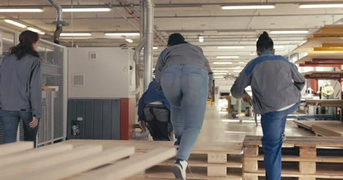 Fellow carpentry apprentices sitting on pallet in the wood workshop Stock Footage 254679523