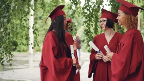 Fellow students are talking and laughing after graduation ceremony holding Stock Footage