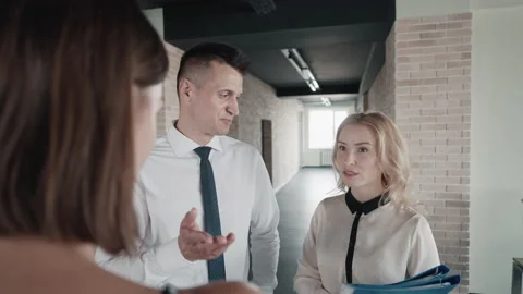 Fellow workers gossip in the hallway Stock Footage 164895536