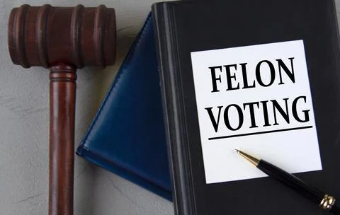 FELON VOTING - words on a white sheet with leather notebooks, a judge's ham.. Stock Photos