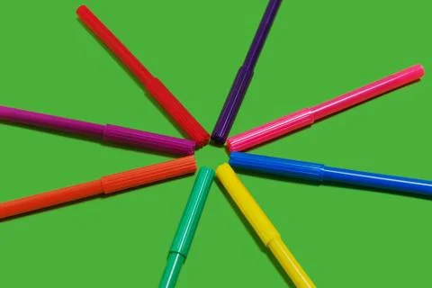 Felt pens lying cap to cap on a green background Stock Photos