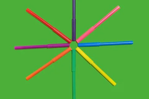Felt pens lying cap to cap on a green surface Stock Photos