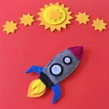 Felt Rocket Ship Flat Lay with Yellow Stars on Red Stock Photos