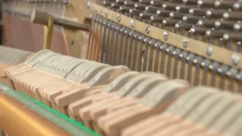 Felted mallets actively strike strings to produce sound or music when a person Stock Footage 156527977